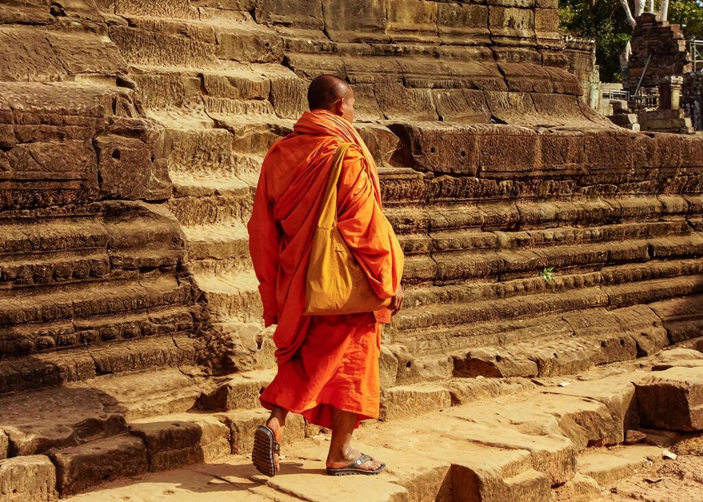 Mnich idący w kompleksie świątynnym Angkor Wat Mnich idący w kompleksie świątynnym Angkor Wat
